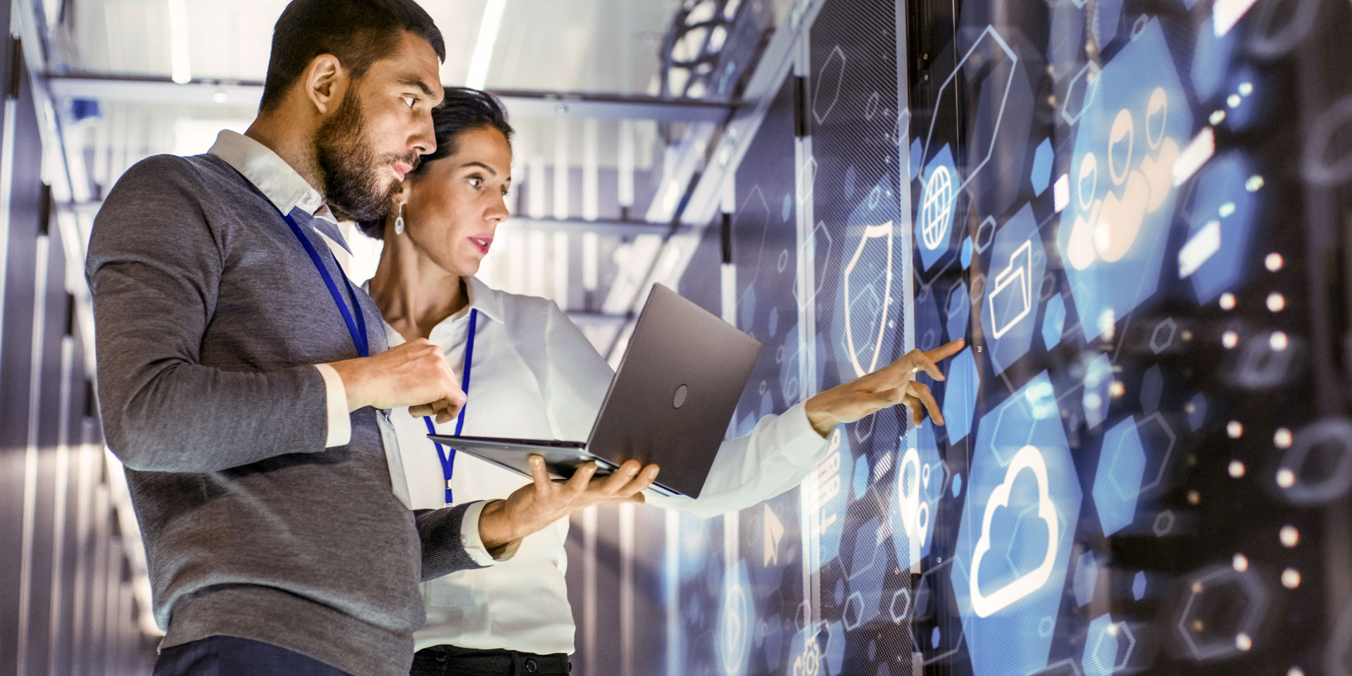 A man and a woman working with a large digital display