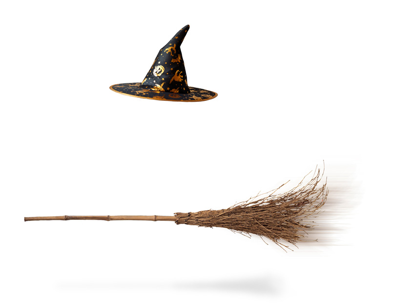 witches hat and broom floating on white