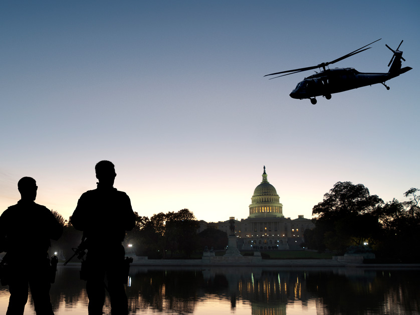 homeland security police silhouette watching capitol and helicopter