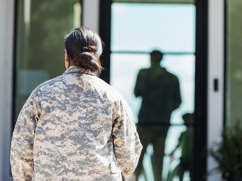 back of female soldier returning home
