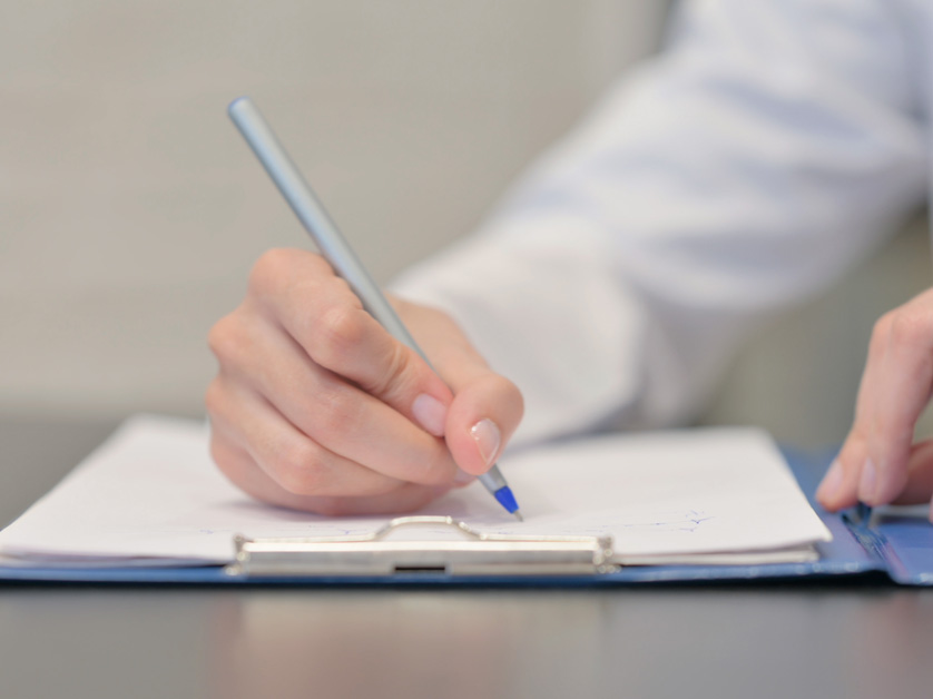 close up hands writing medical notes