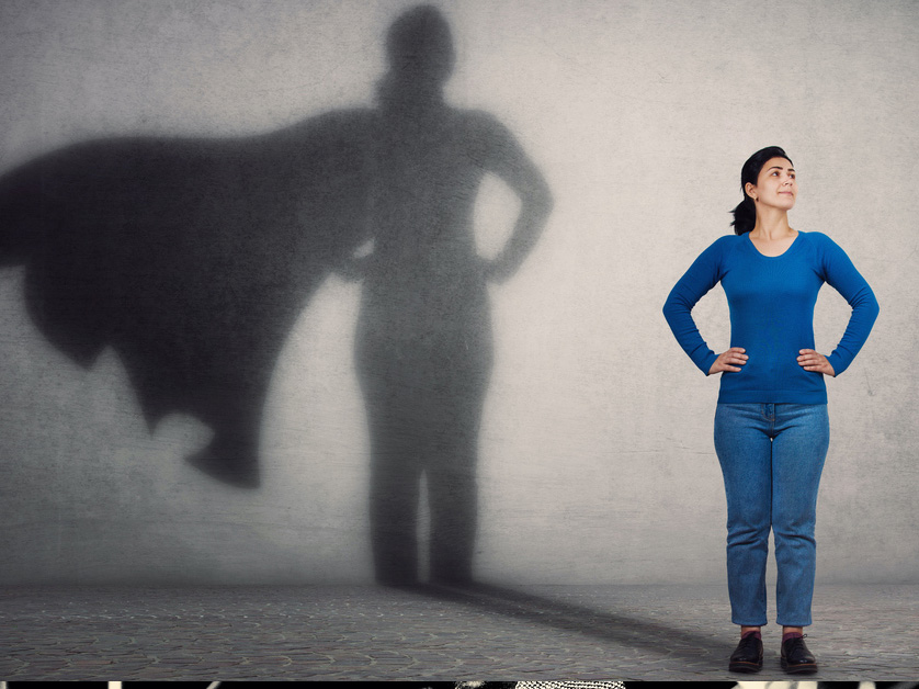 woman standing in superhero shadow