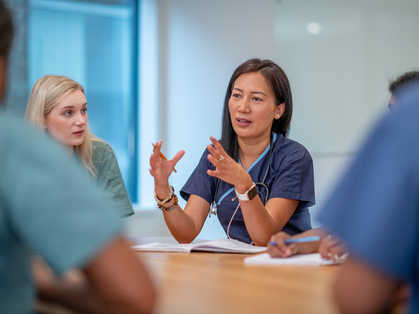 nurse at board room table talking