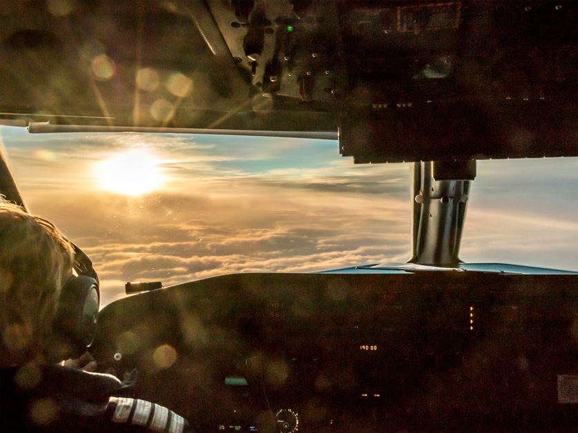pilot flying plane at sunset