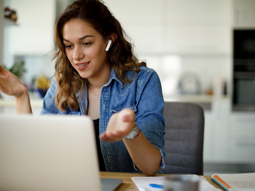 woman with headphones talking to computer
