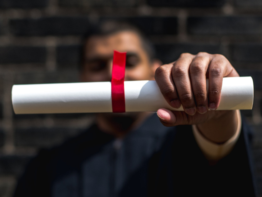 man holding rolled up diploma